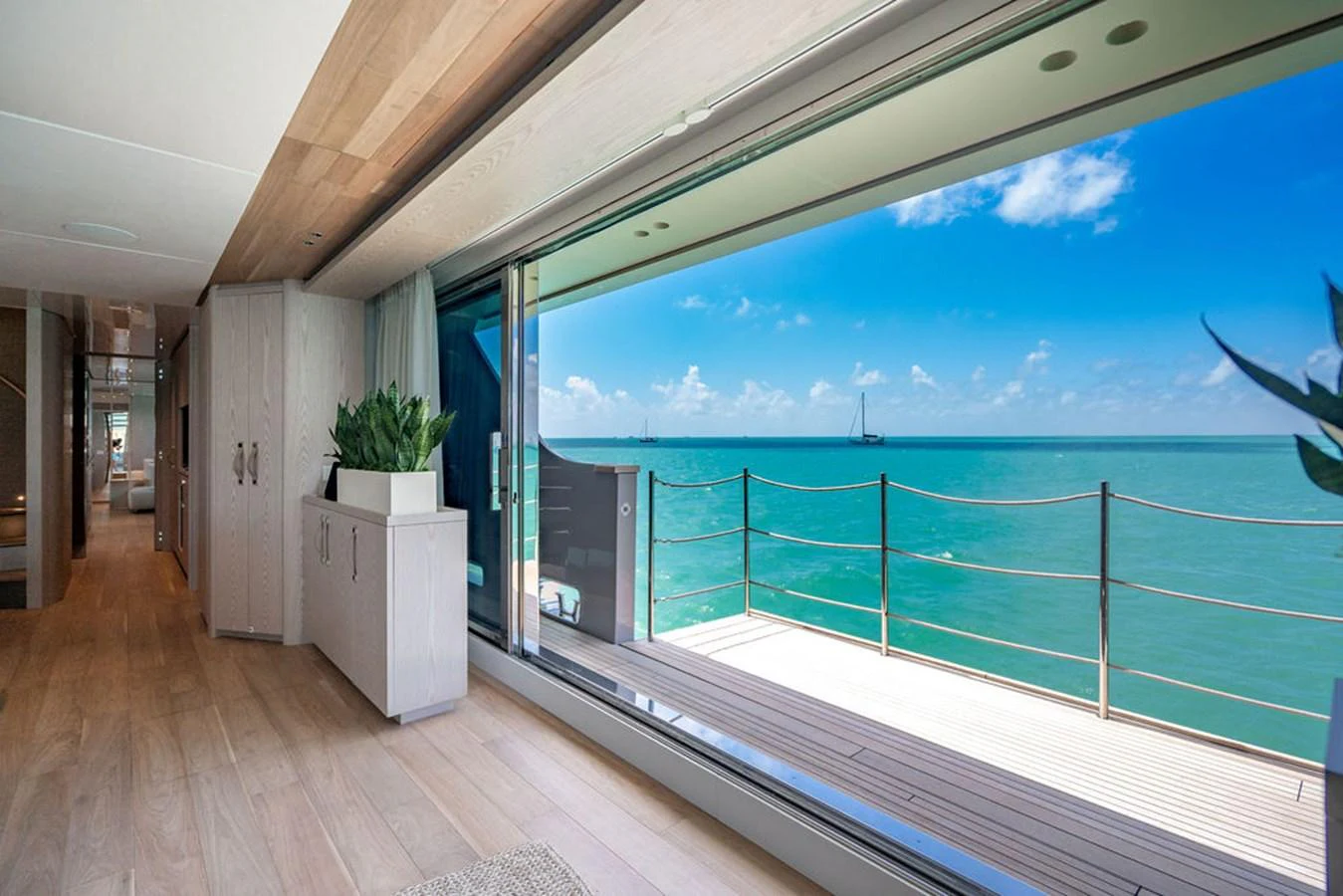 The salon offers a stunning view of the ocean through large sliding glass doors, creating a seamless indoor-outdoor living experience. aboard SANLORENZO SD118/129 Yacht for Sale