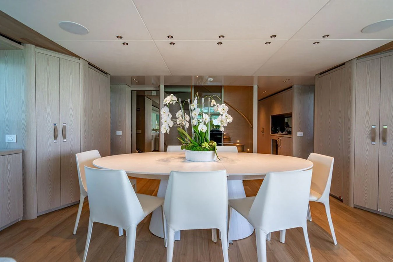 A stylish dining area with a modern table and chairs, complemented by a beautiful orchid centerpiece. aboard SANLORENZO SD118/129 Yacht for Sale