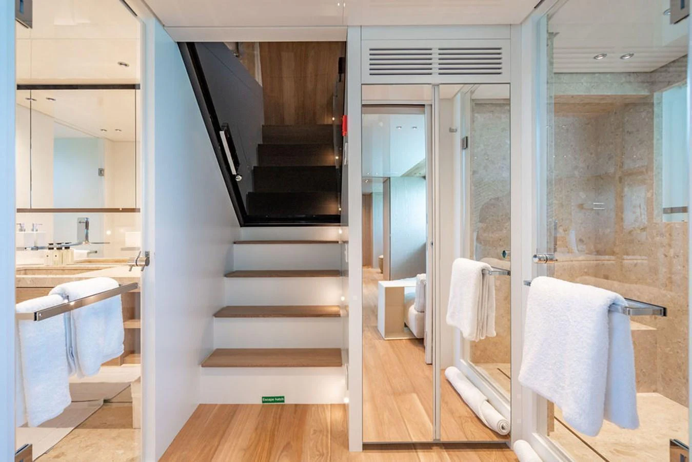 The yacht's interior features a modern staircase leading to different levels, surrounded by glass and wood finishes. aboard SANLORENZO SD118/129 Yacht for Sale