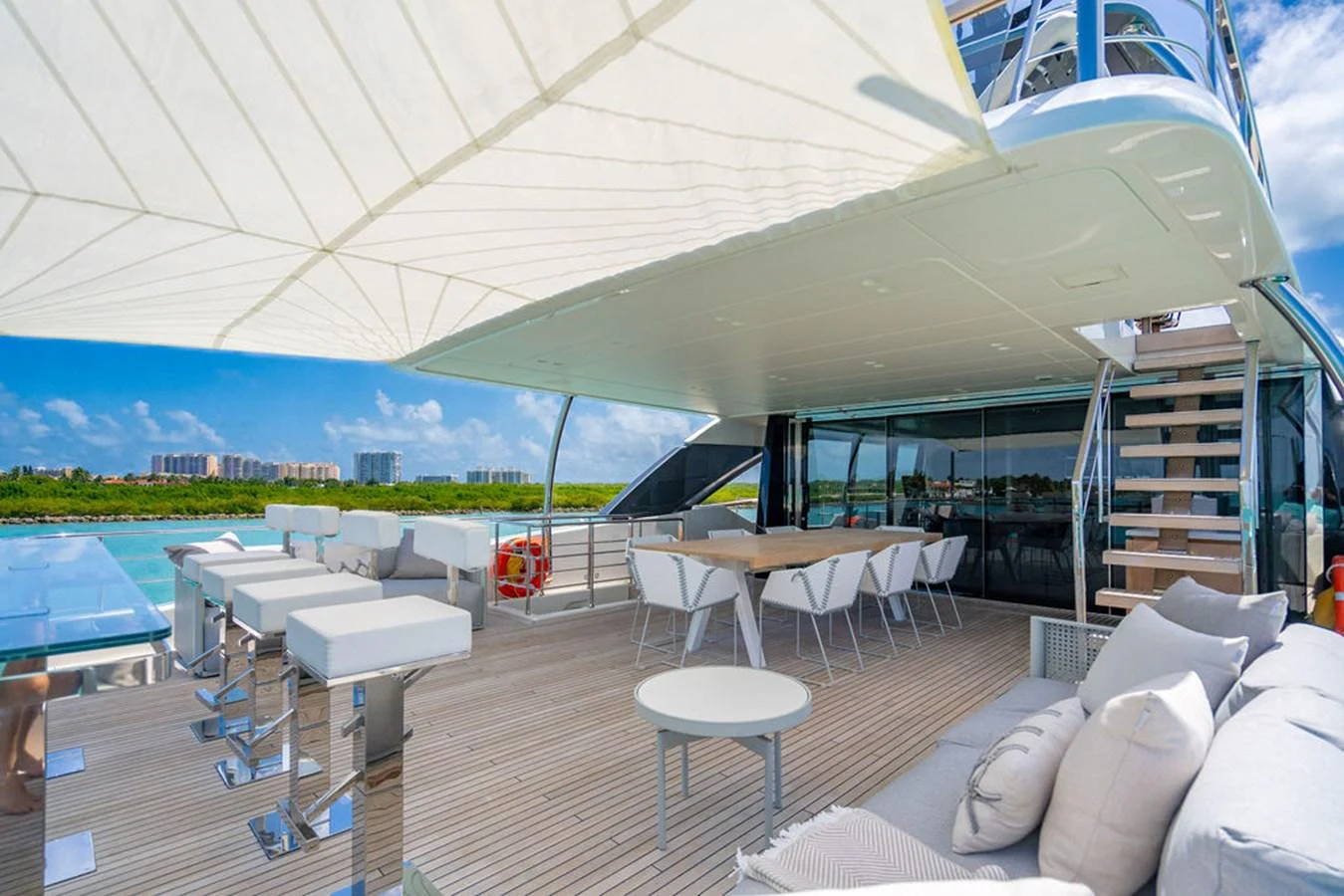 The spacious aft deck features comfortable seating, a dining area, and a shaded lounging space with a view of the water. aboard SANLORENZO SD118/129 Yacht for Sale