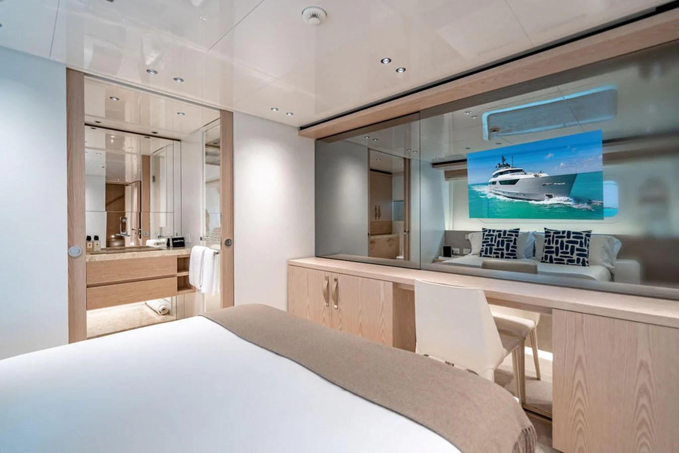 A luxurious stateroom featuring a comfortable bed, modern furnishings, and a large mirror reflecting the bathroom area. aboard SANLORENZO SD118/129 Yacht for Sale