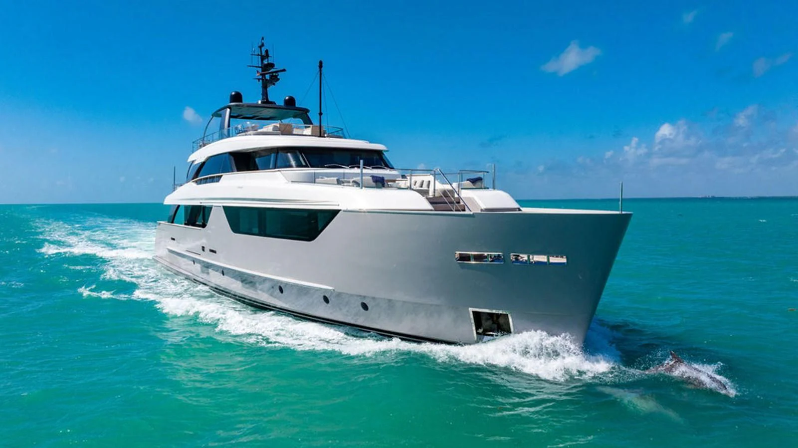 A sleek and modern yacht cruises through clear turquoise waters under a bright blue sky. aboard SANLORENZO SD118/129 Yacht for Sale
