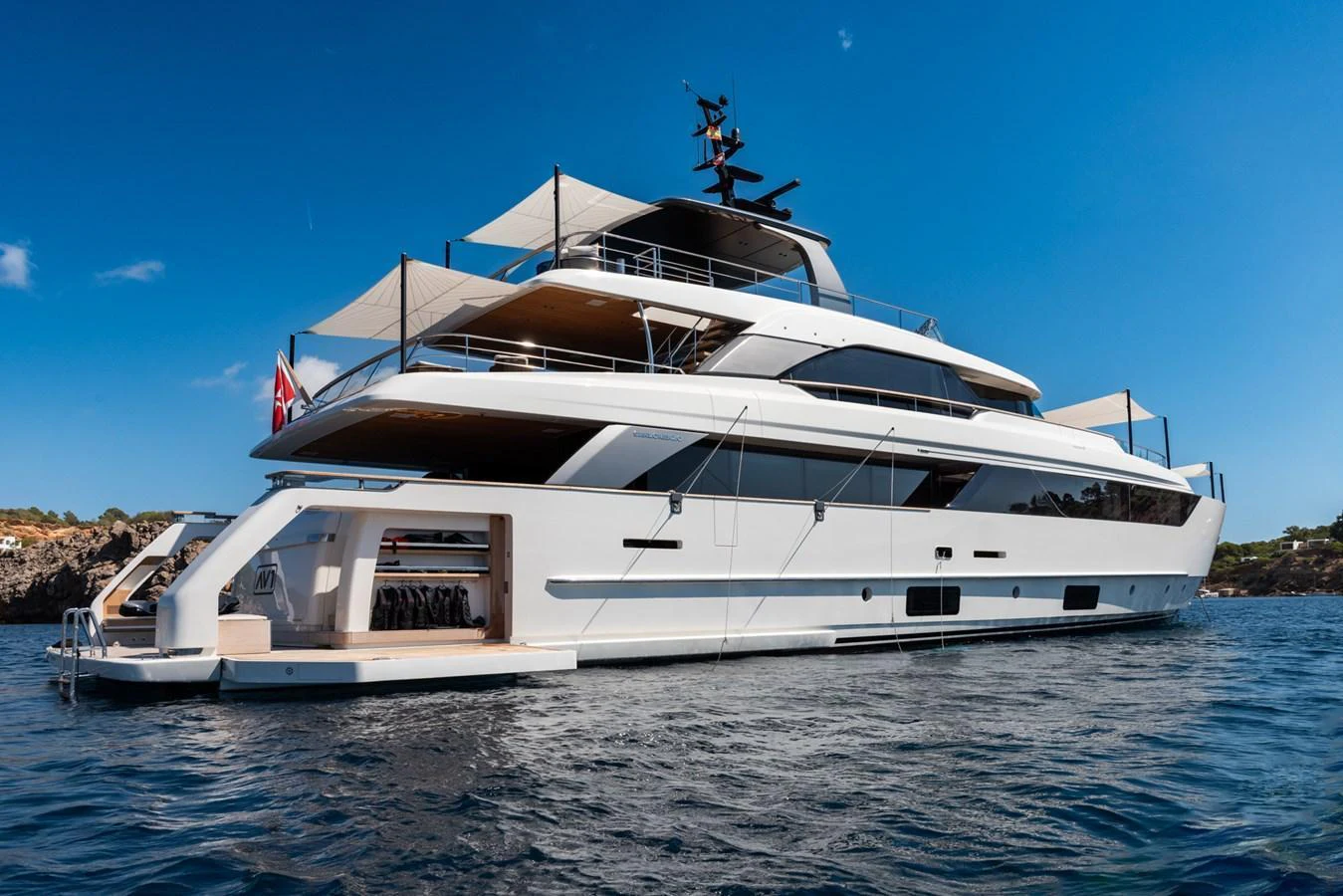 A sleek and modern yacht with multiple decks, anchored in calm waters under a clear blue sky. aboard AV1 Yacht for Sale
