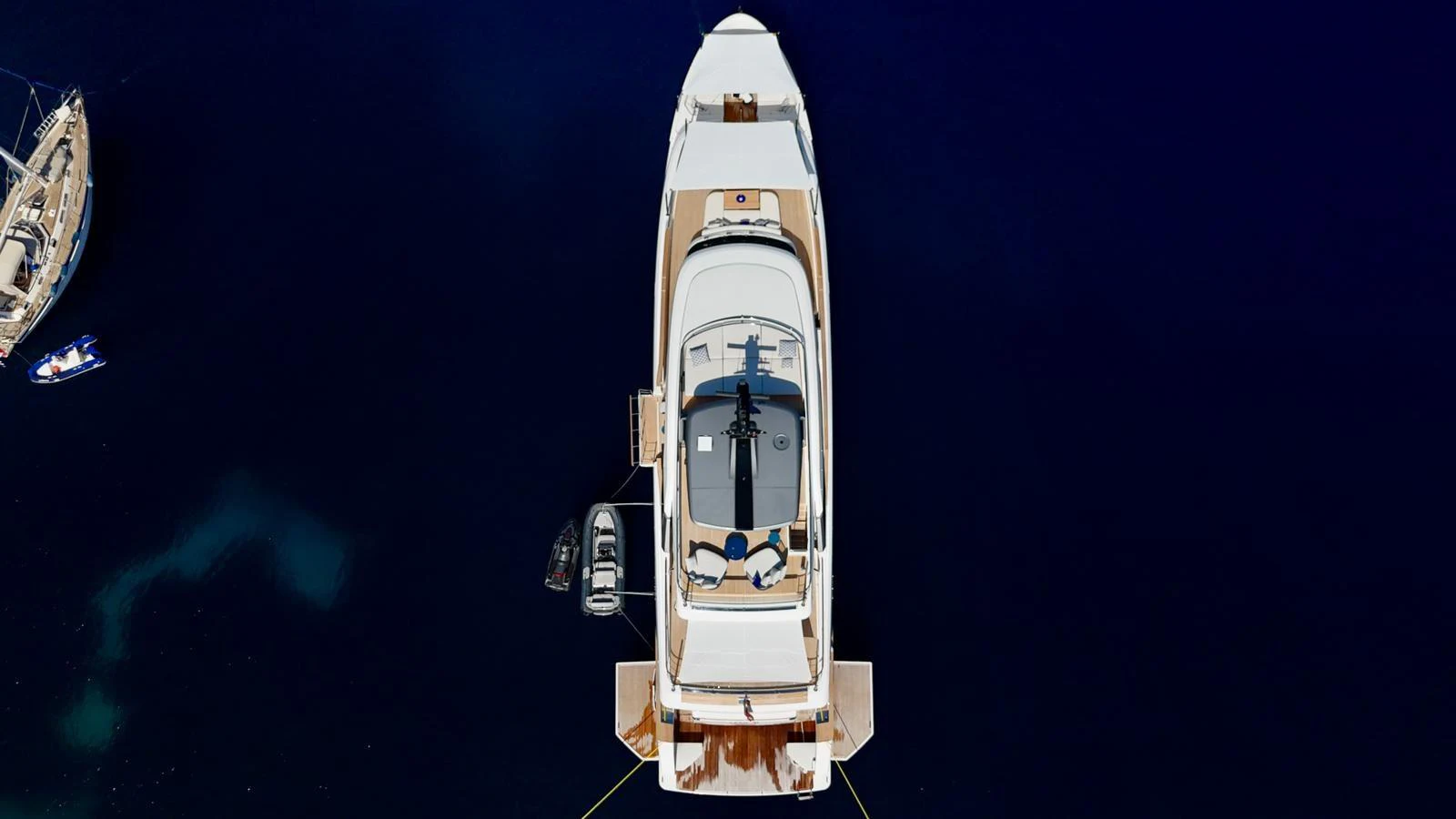 Aerial view of a luxurious yacht anchored in deep blue waters, showcasing its sleek design and spacious deck areas. aboard AV1 Yacht for Sale