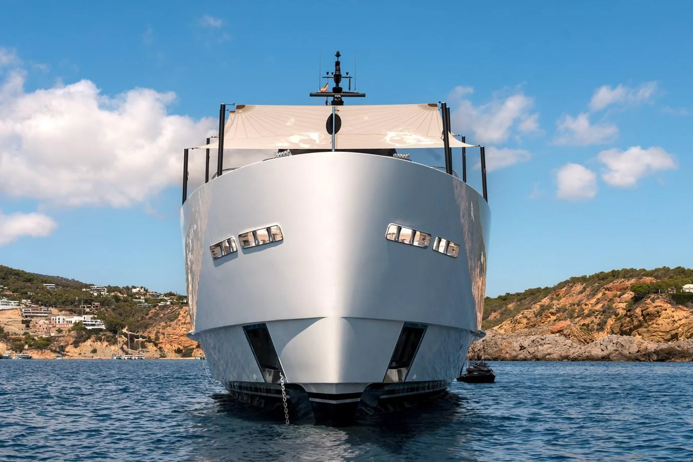 A modern yacht with sleek lines is anchored in a picturesque coastal area. aboard AV1 Yacht for Sale