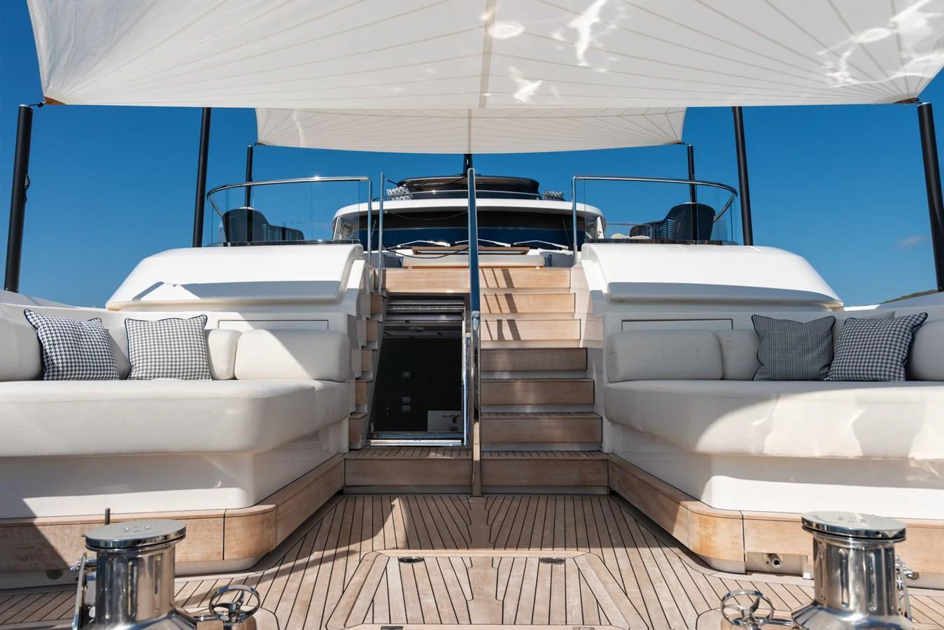 The aft deck features comfortable seating and a staircase leading to the upper deck, all under a stylish canopy. aboard AV1 Yacht for Sale