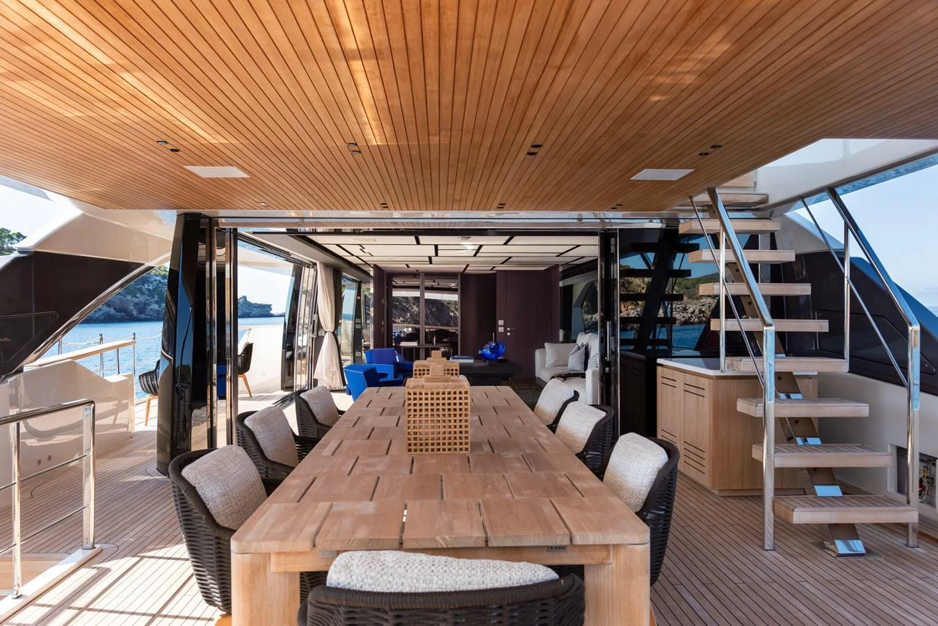 The aft deck features a spacious dining area with a wooden table and comfortable seating, perfect for alfresco dining. aboard AV1 Yacht for Sale