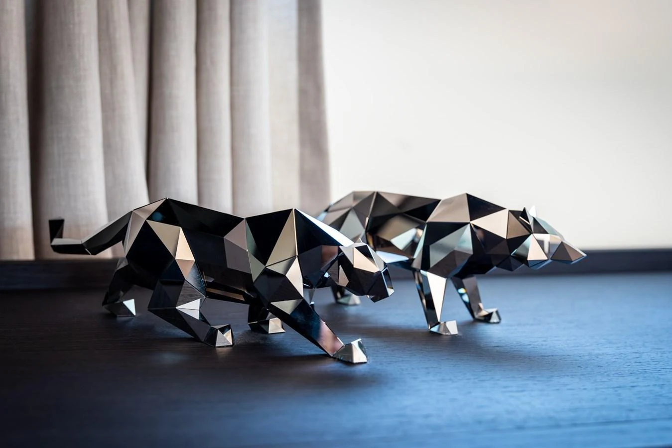 A pair of modern, geometric animal sculptures adorn a dark wooden surface, adding an artistic touch to the yacht's interior. aboard AV1 Yacht for Sale