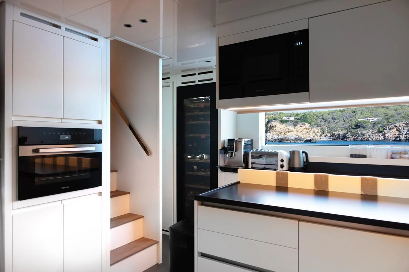 The modern galley features sleek cabinetry, state-of-the-art appliances, and a scenic view through the window. aboard AV1 Yacht for Sale