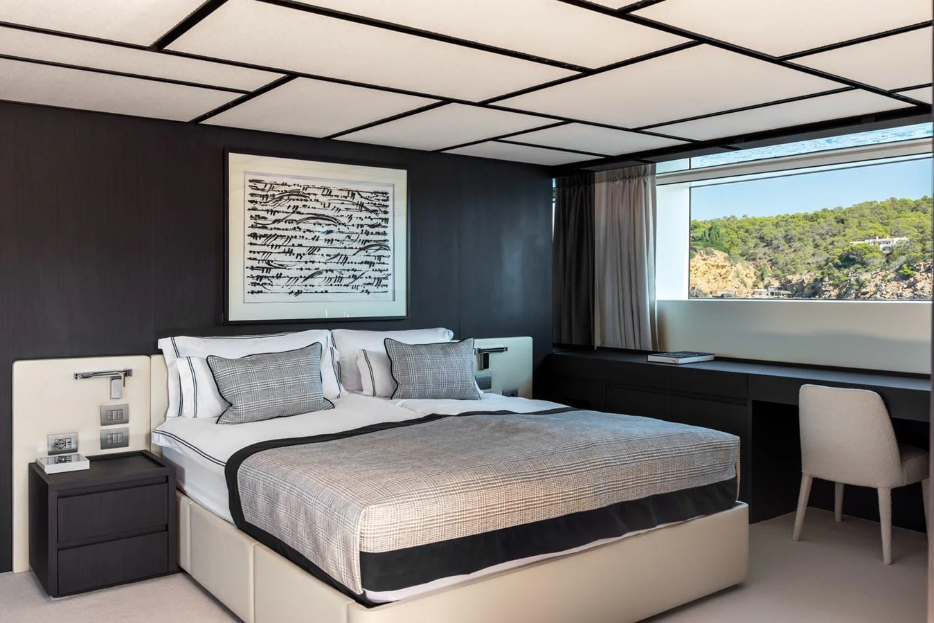 The stateroom features a modern design with a large bed, stylish decor, and a scenic window view. aboard AV1 Yacht for Sale