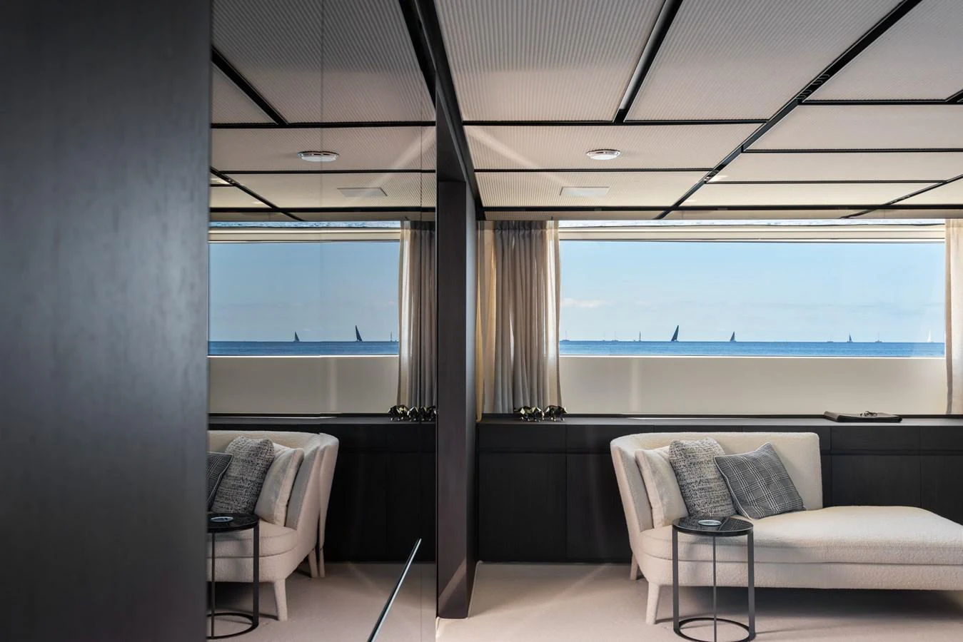 The yacht's interior features a comfortable seating area with a view of the ocean through large windows. aboard AV1 Yacht for Sale
