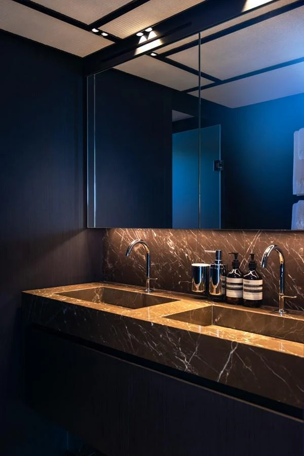 A luxurious bathroom with a sleek, modern design featuring a double sink and elegant fixtures. aboard AV1 Yacht for Sale