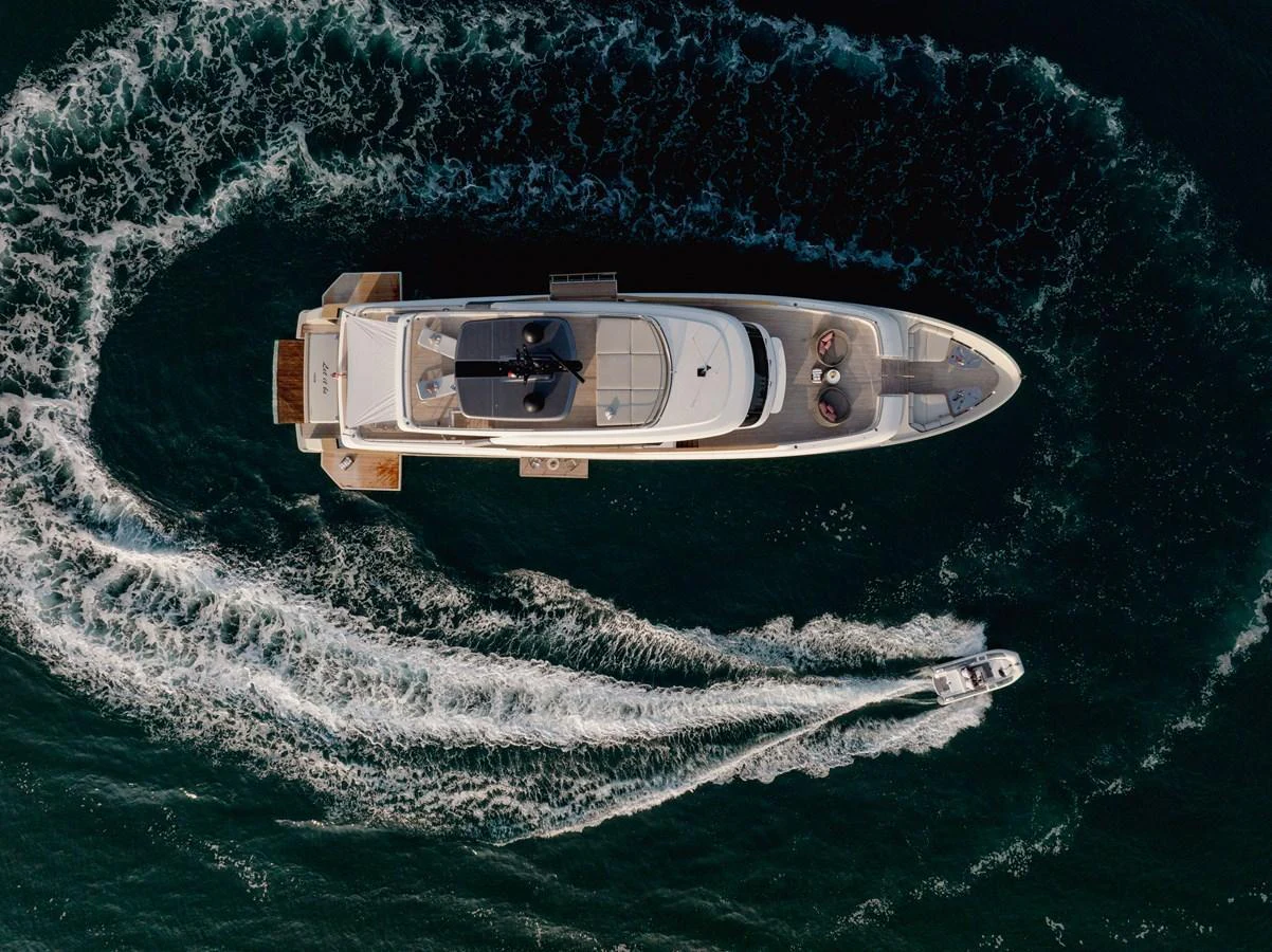 An aerial view of a luxurious yacht cruising through the water, leaving a trail of waves behind. aboard LET IT BE Yacht for Sale