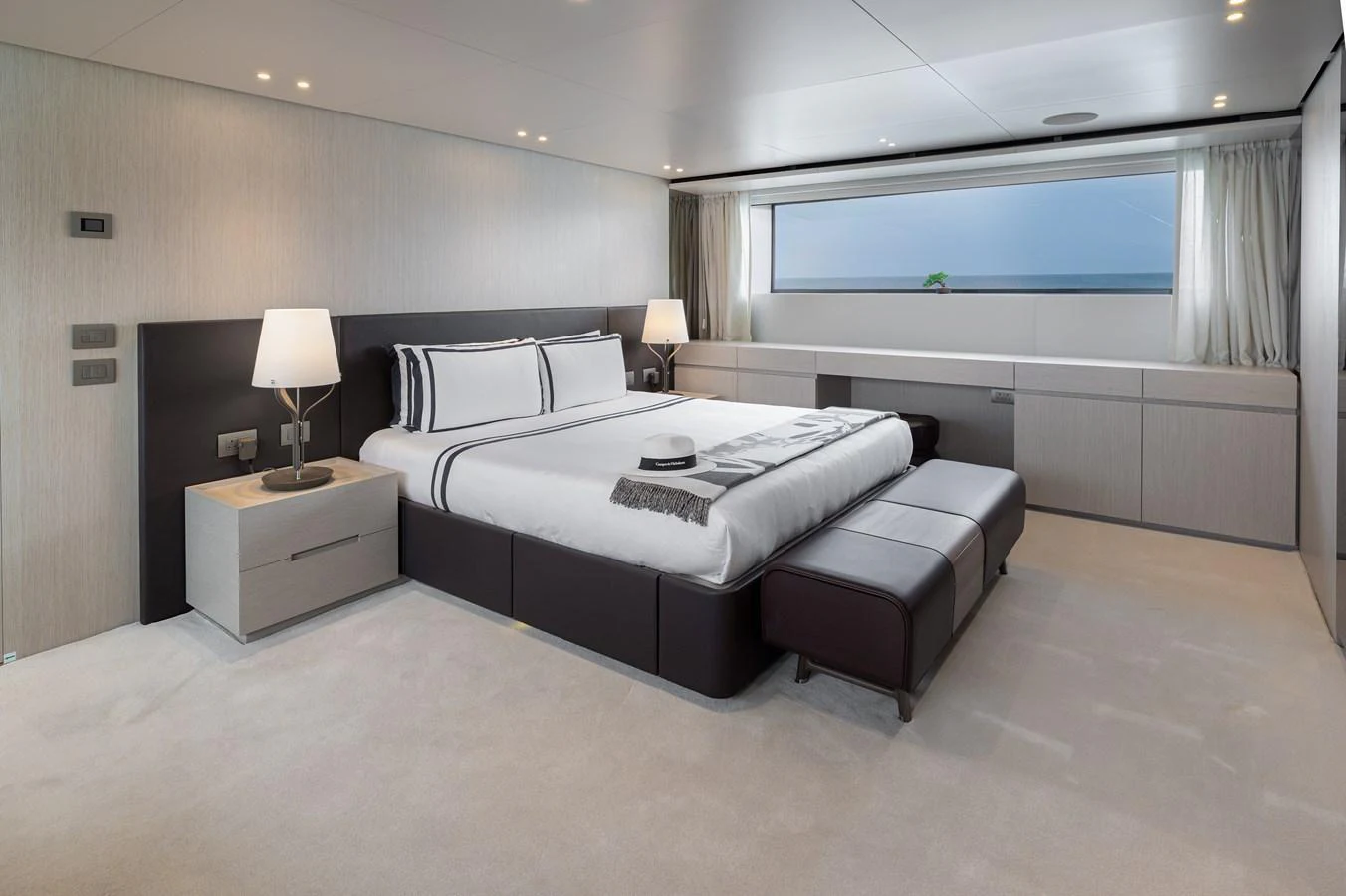 The master stateroom features a luxurious bed with modern decor and ample natural light. aboard LET IT BE Yacht for Sale