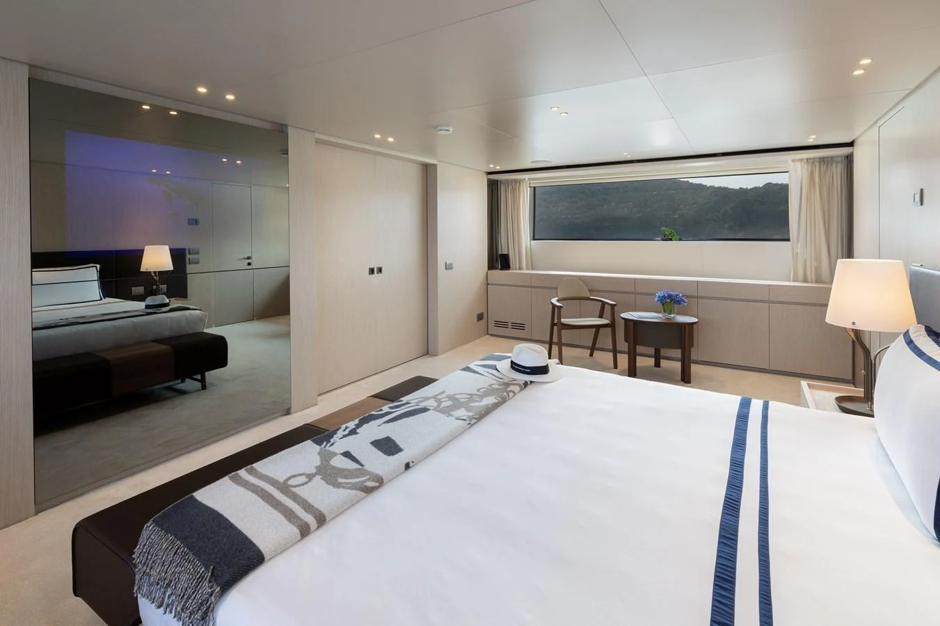 A spacious and elegantly designed stateroom with a large bed and scenic window view. aboard LET IT BE Yacht for Sale