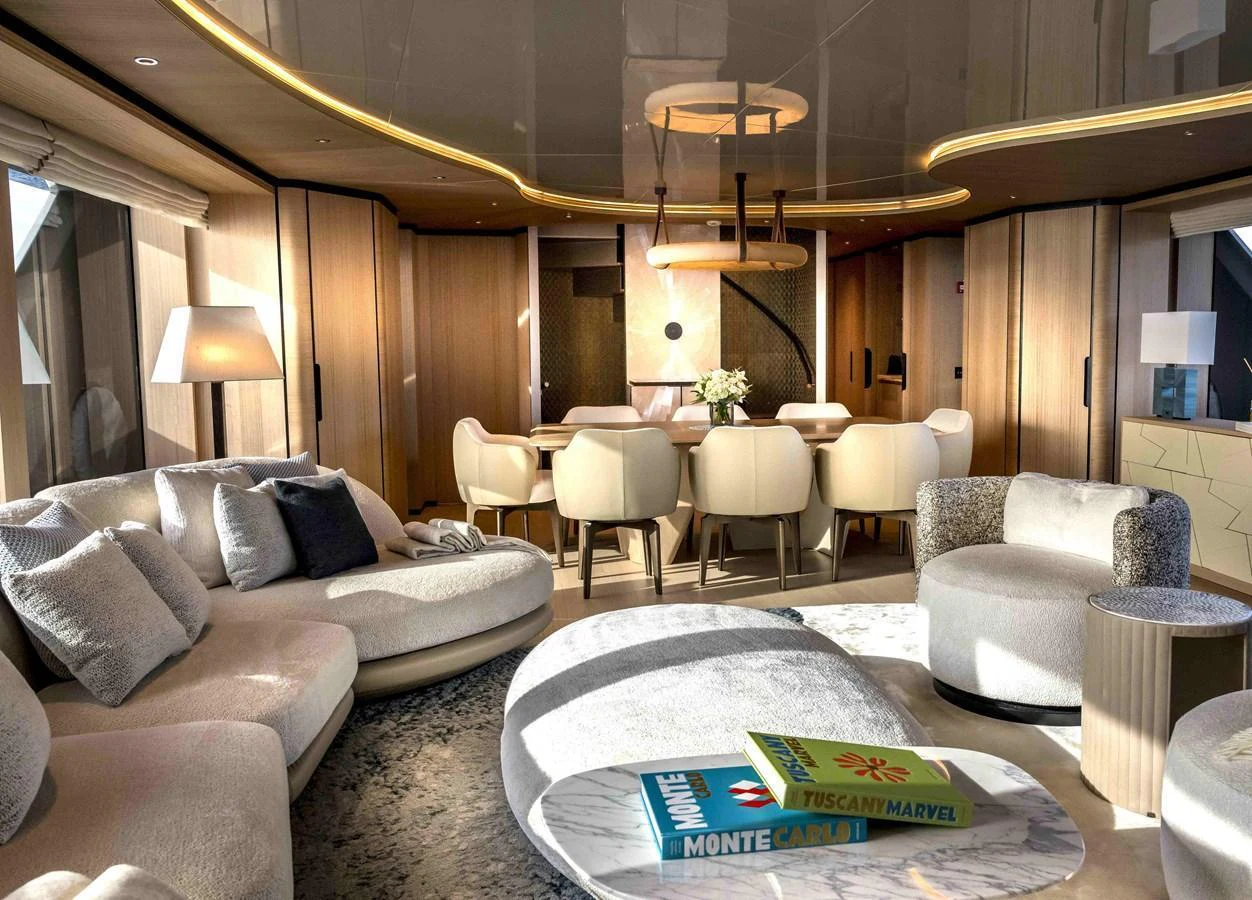 The yacht's salon features luxurious seating and a stylish dining area bathed in natural light. aboard UNIQUE S Yacht for Sale