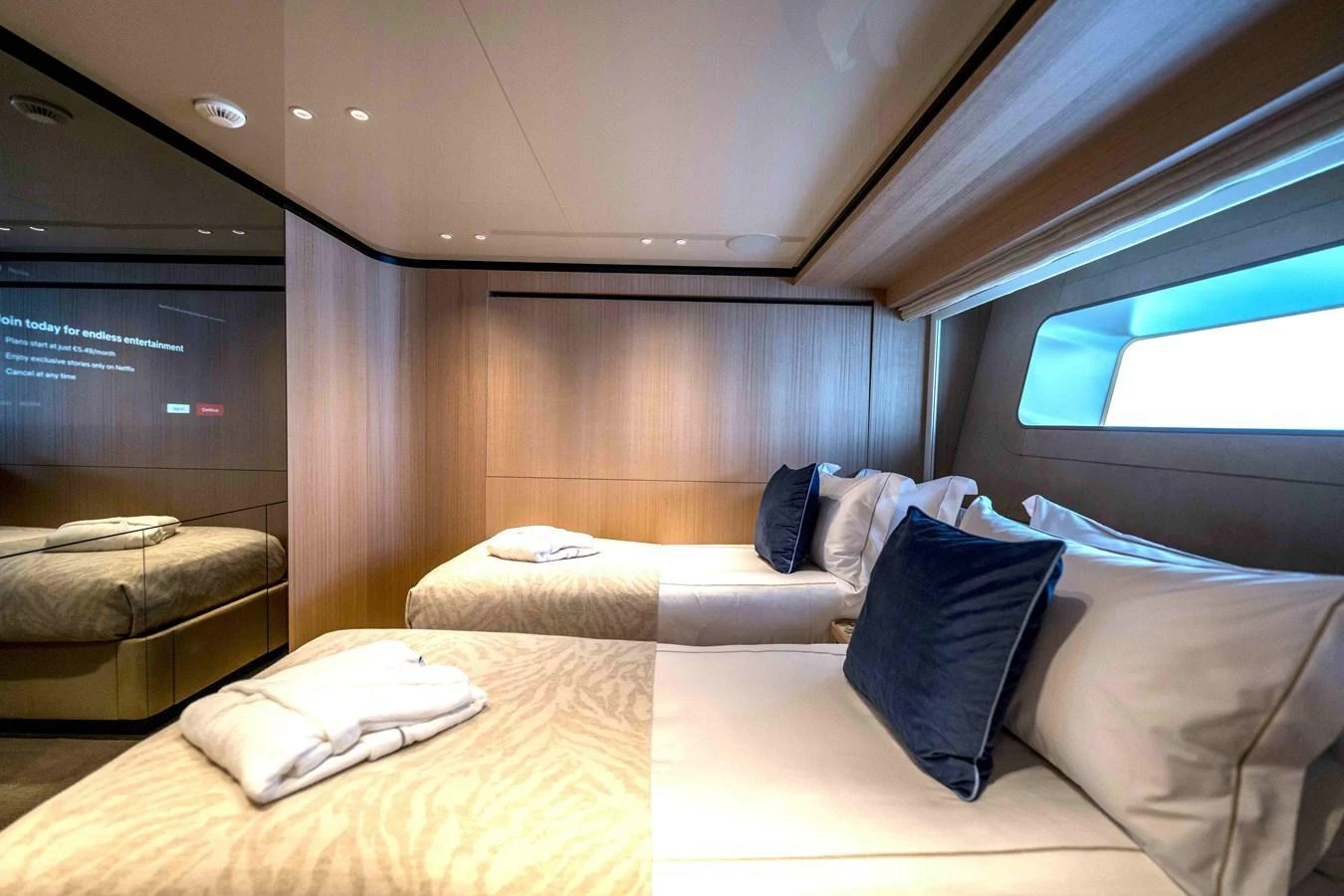 The guest stateroom features twin beds with plush bedding and a sleek, modern design. aboard UNIQUE S Yacht for Sale