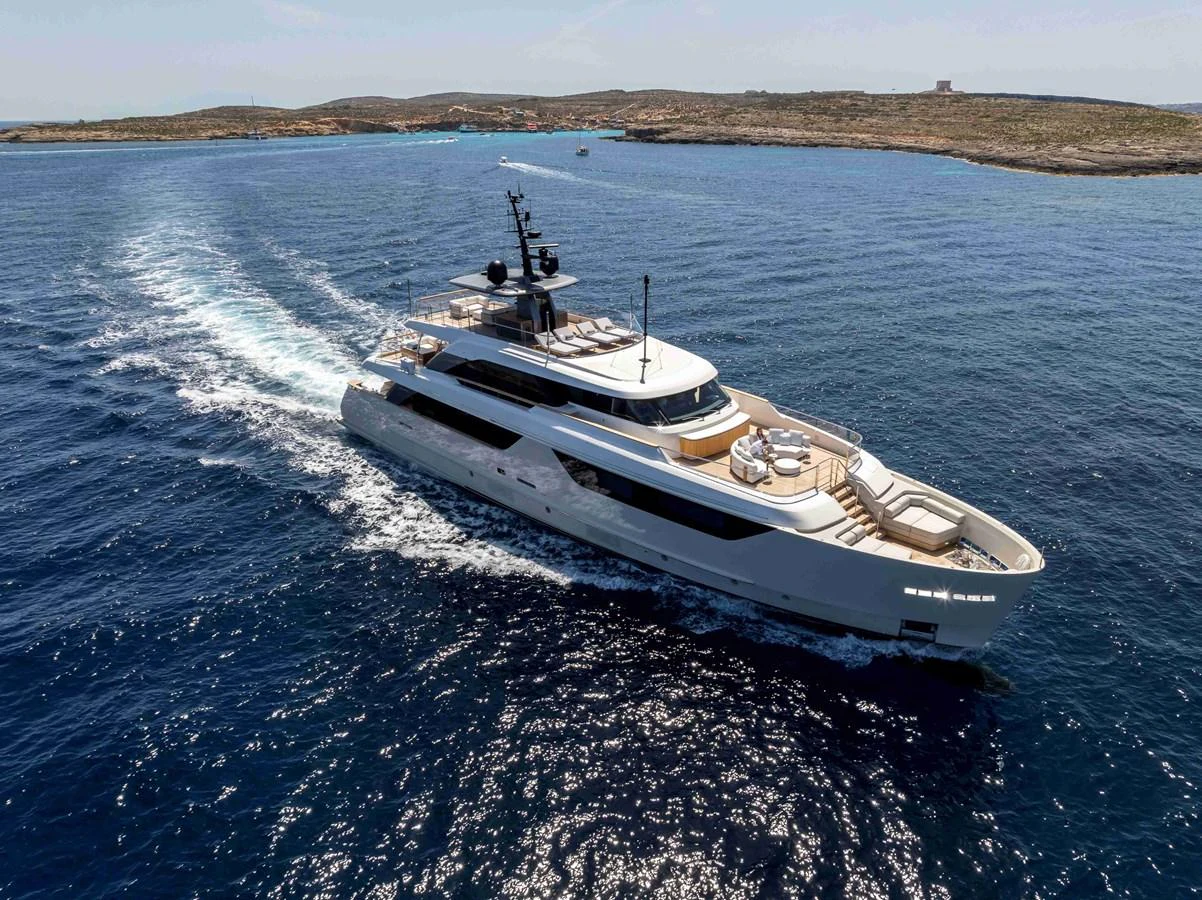 A sleek and modern yacht cruises through clear blue waters, showcasing its elegant design and spacious decks. aboard UNIQUE S Yacht for Sale