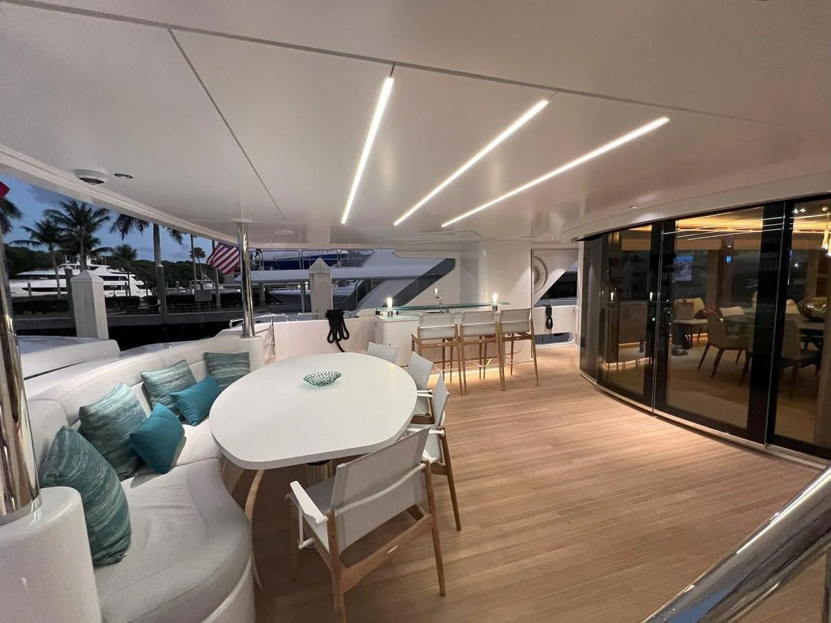 The aft deck features a stylish dining area with modern seating and ambient lighting. aboard WESTPORT 117 / 35M Yacht for Sale