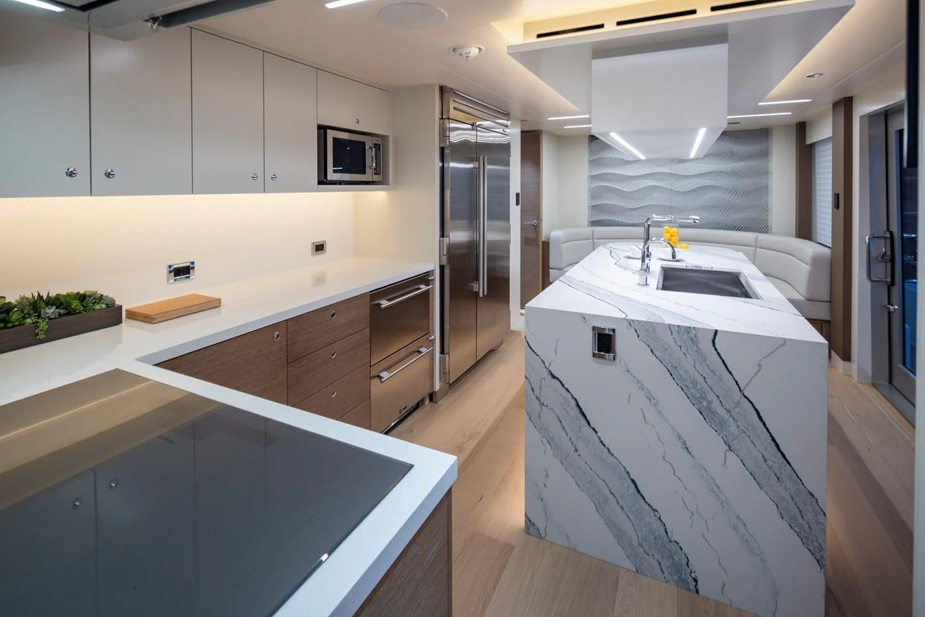 The modern galley features sleek cabinetry, high-end appliances, and a stylish marble island. aboard WESTPORT 117 / 35M Yacht for Sale