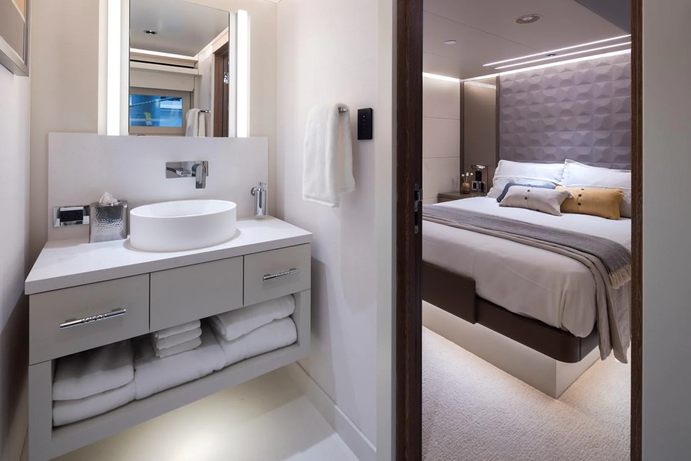 The image showcases a luxurious stateroom with an adjoining modern bathroom. aboard WESTPORT 117 / 35M Yacht for Sale