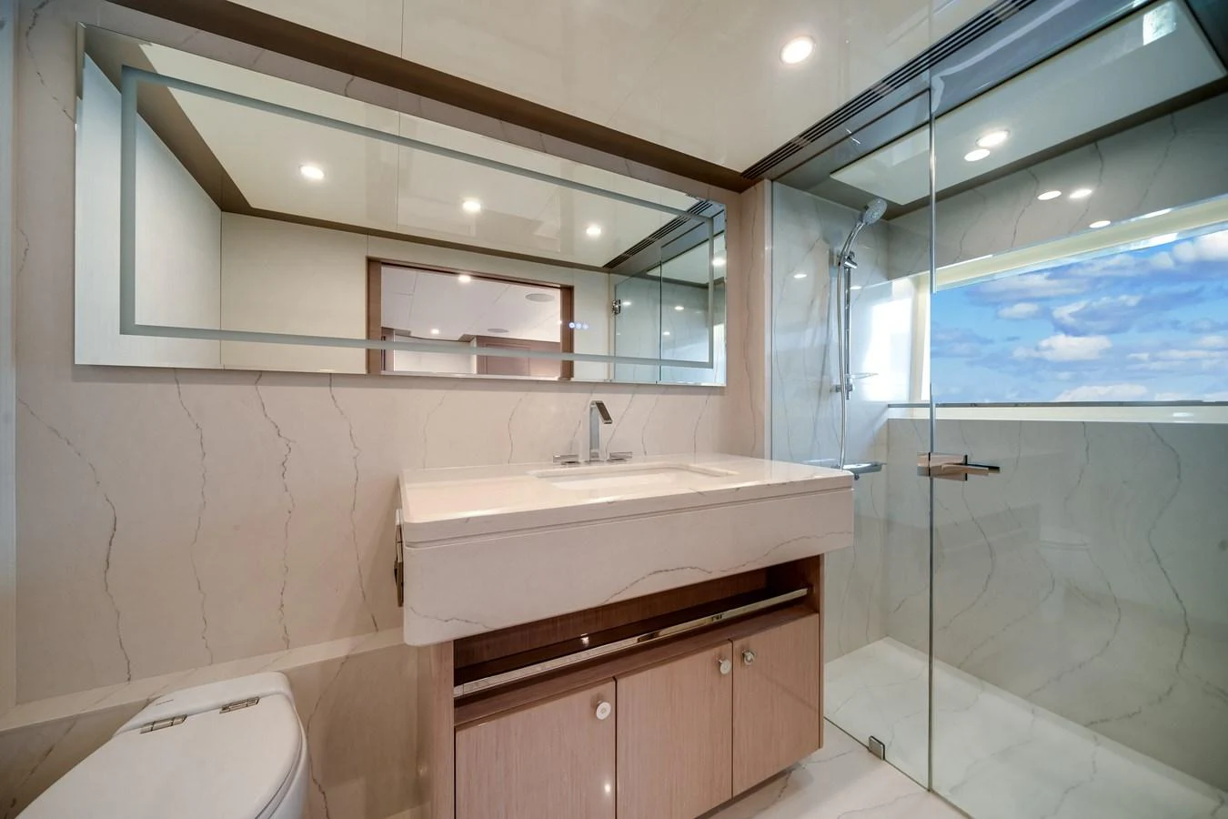 The yacht's bathroom features a sleek design with a large mirror and a glass-enclosed shower. aboard OCEAN ALEXANDER 37L Yacht for Sale
