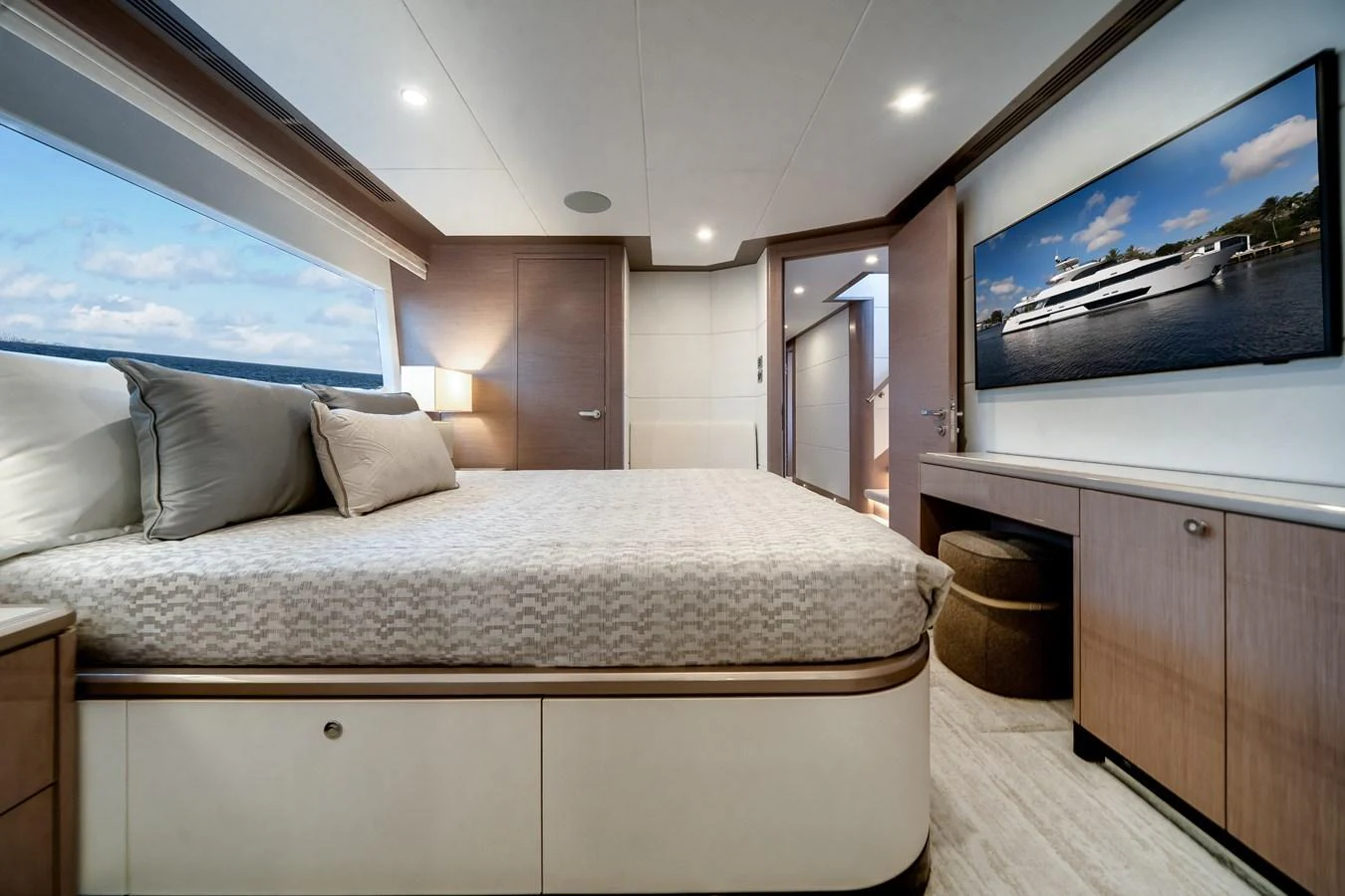 A luxurious stateroom with a large bed, modern furnishings, and a scenic view through the window. aboard OCEAN ALEXANDER 37L Yacht for Sale