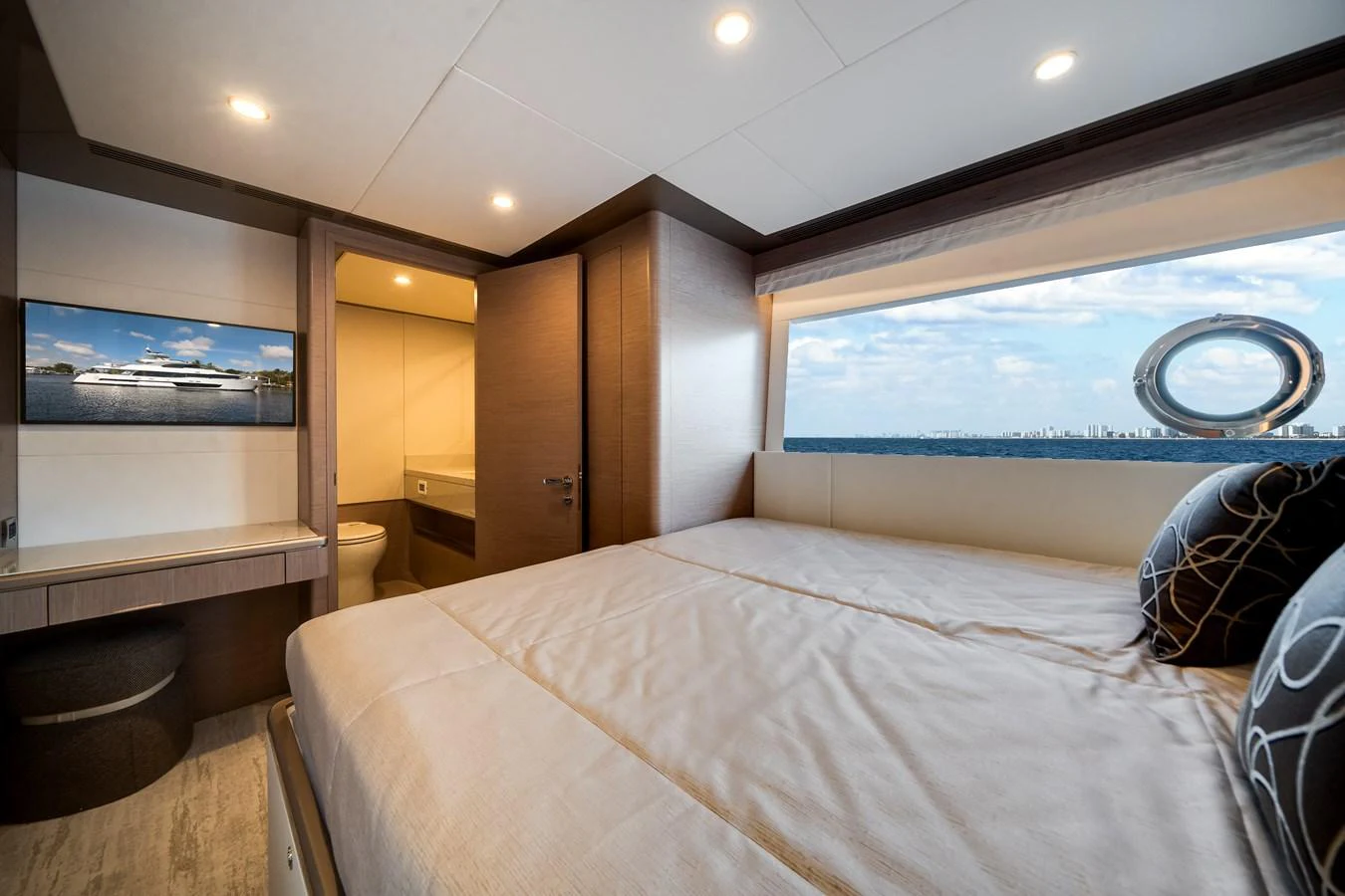 The stateroom features a large bed, modern decor, and a scenic window view. aboard OCEAN ALEXANDER 37L Yacht for Sale