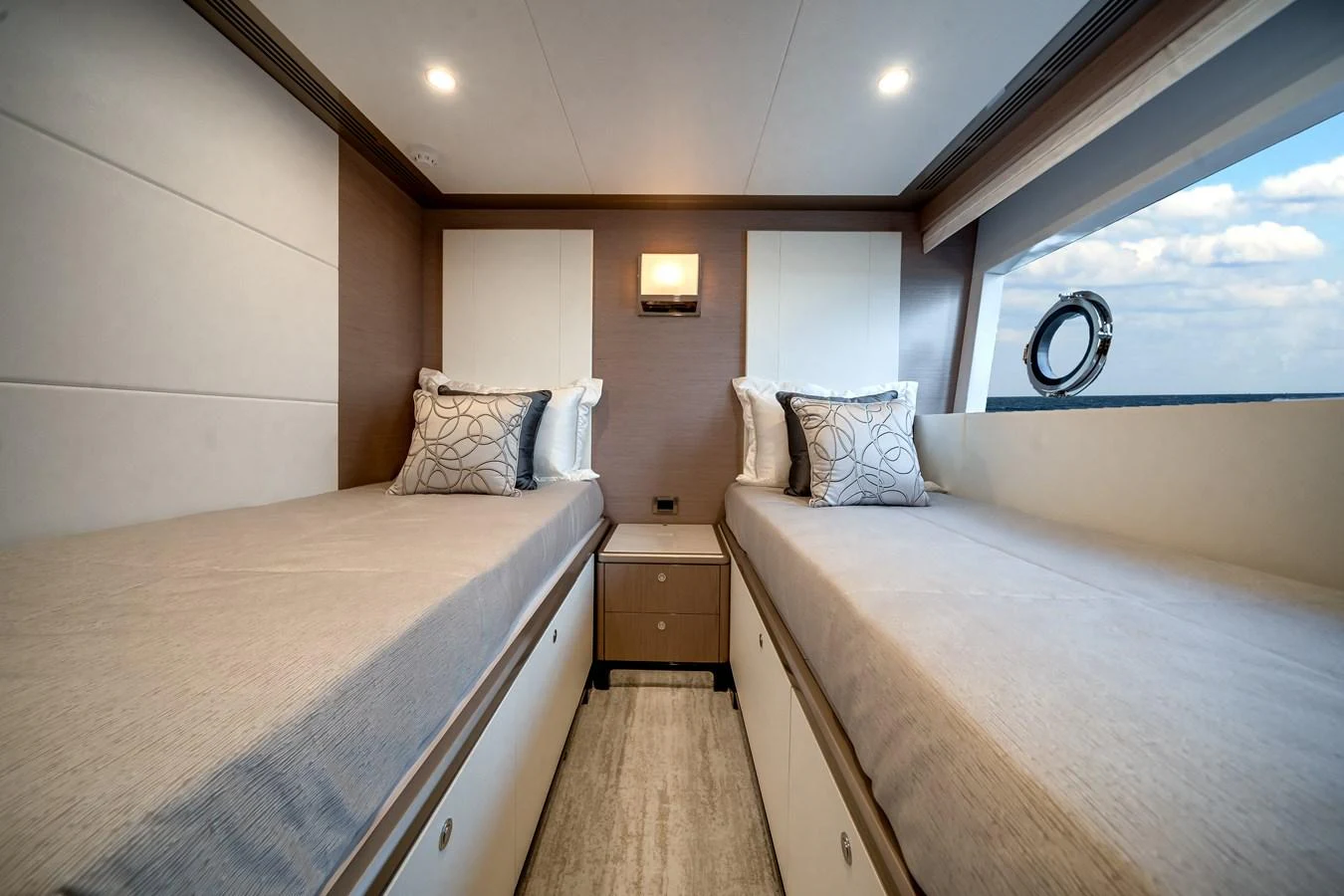 The twin stateroom features two single beds with elegant bedding and a large window for natural light. aboard OCEAN ALEXANDER 37L Yacht for Sale