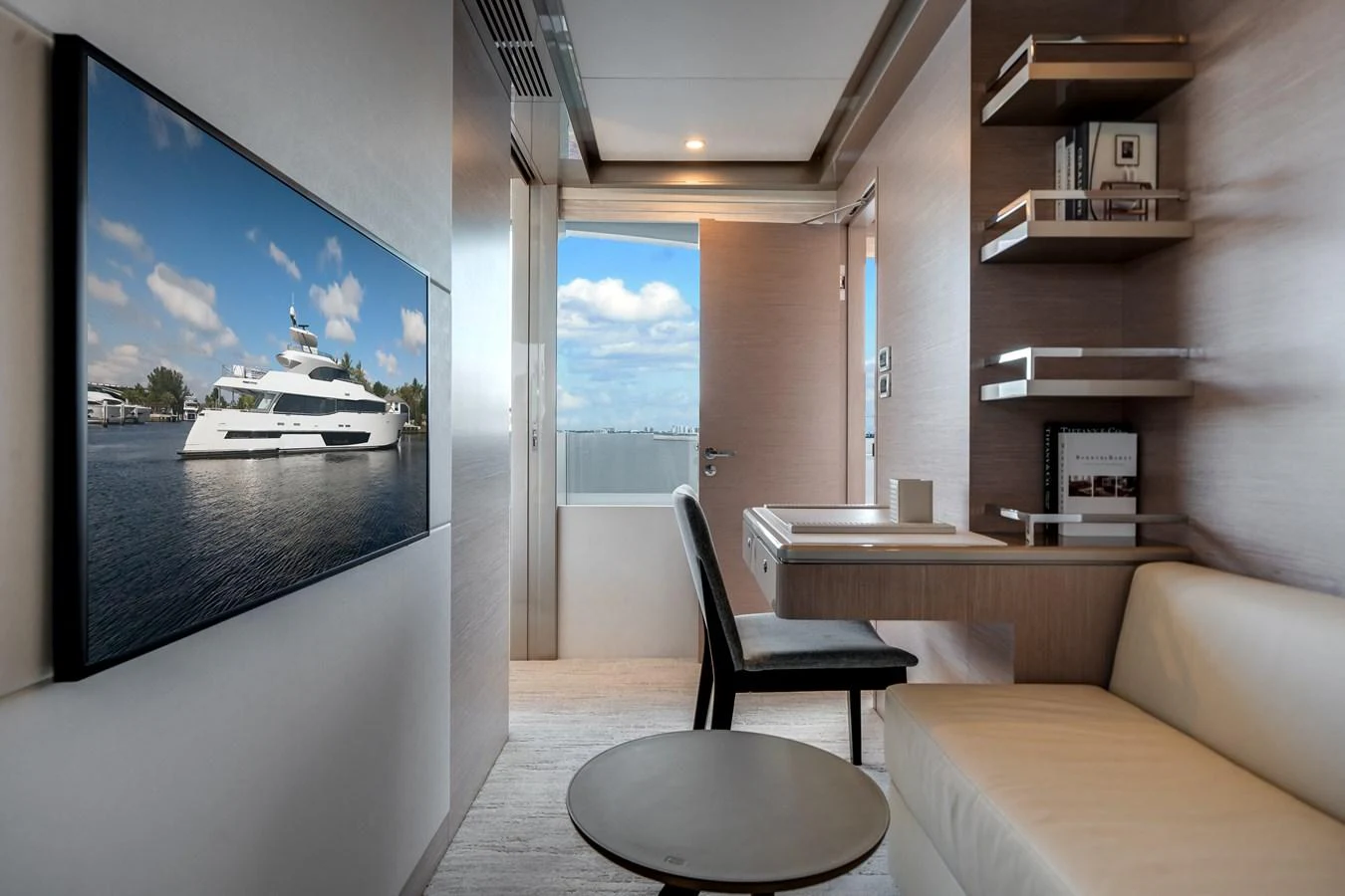 A modern yacht office with a sleek desk, comfortable seating, and a large wall-mounted TV. aboard OCEAN ALEXANDER 37L Yacht for Sale