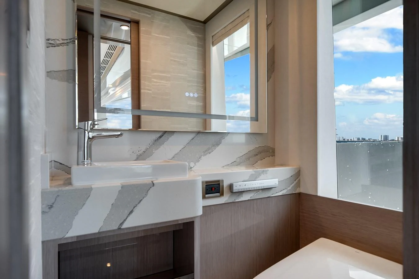 A modern bathroom with a sleek design and a view of the sea through the window. aboard OCEAN ALEXANDER 37L Yacht for Sale