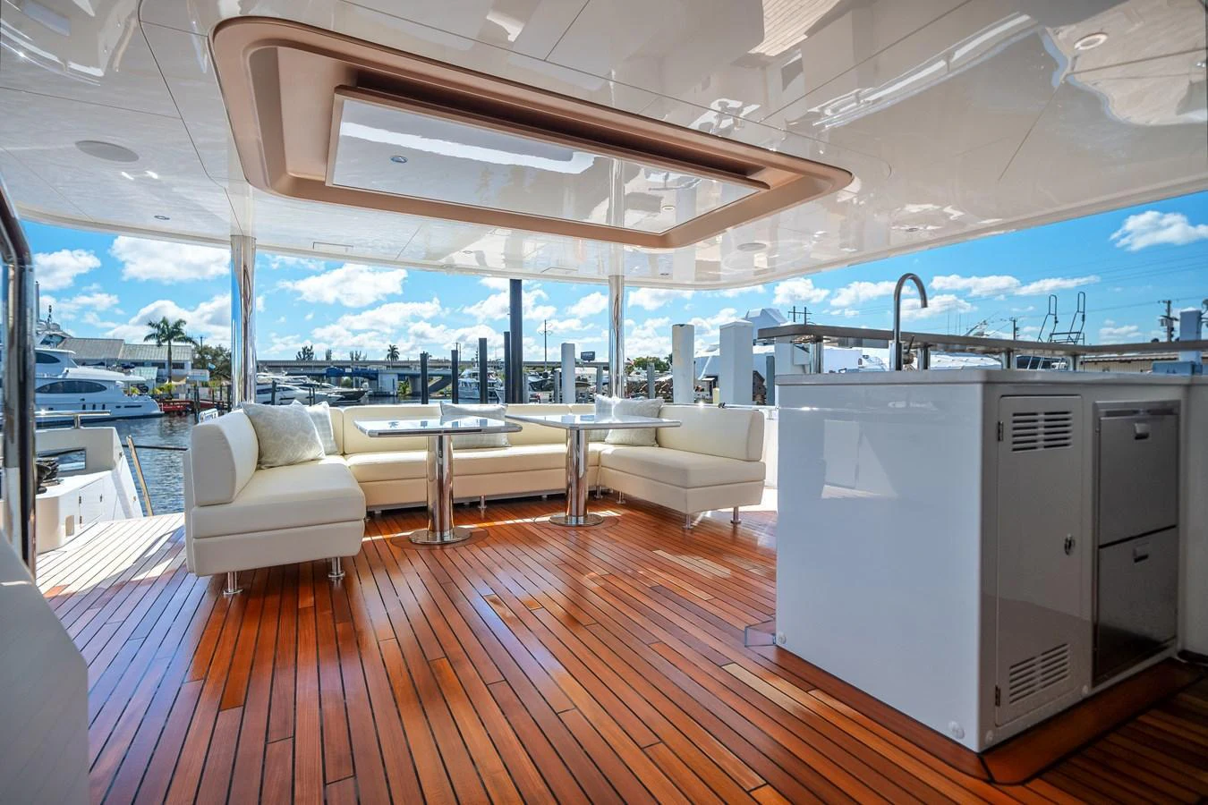 The aft deck features elegant seating and dining areas with a stunning view of the marina. aboard OCEAN ALEXANDER 37L Yacht for Sale