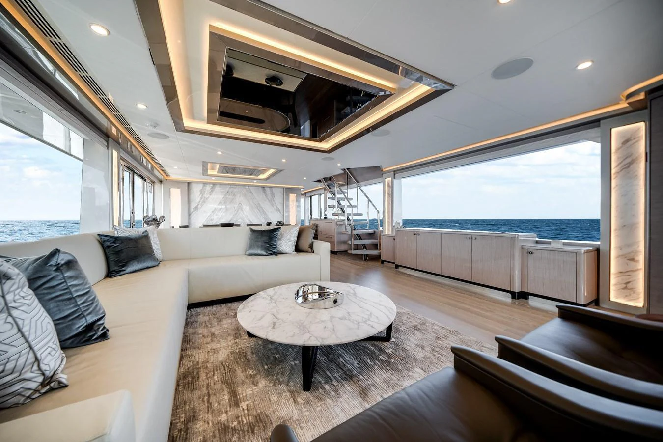 The spacious salon features luxurious seating, a modern coffee table, and expansive ocean views. aboard OCEAN ALEXANDER 37L Yacht for Sale