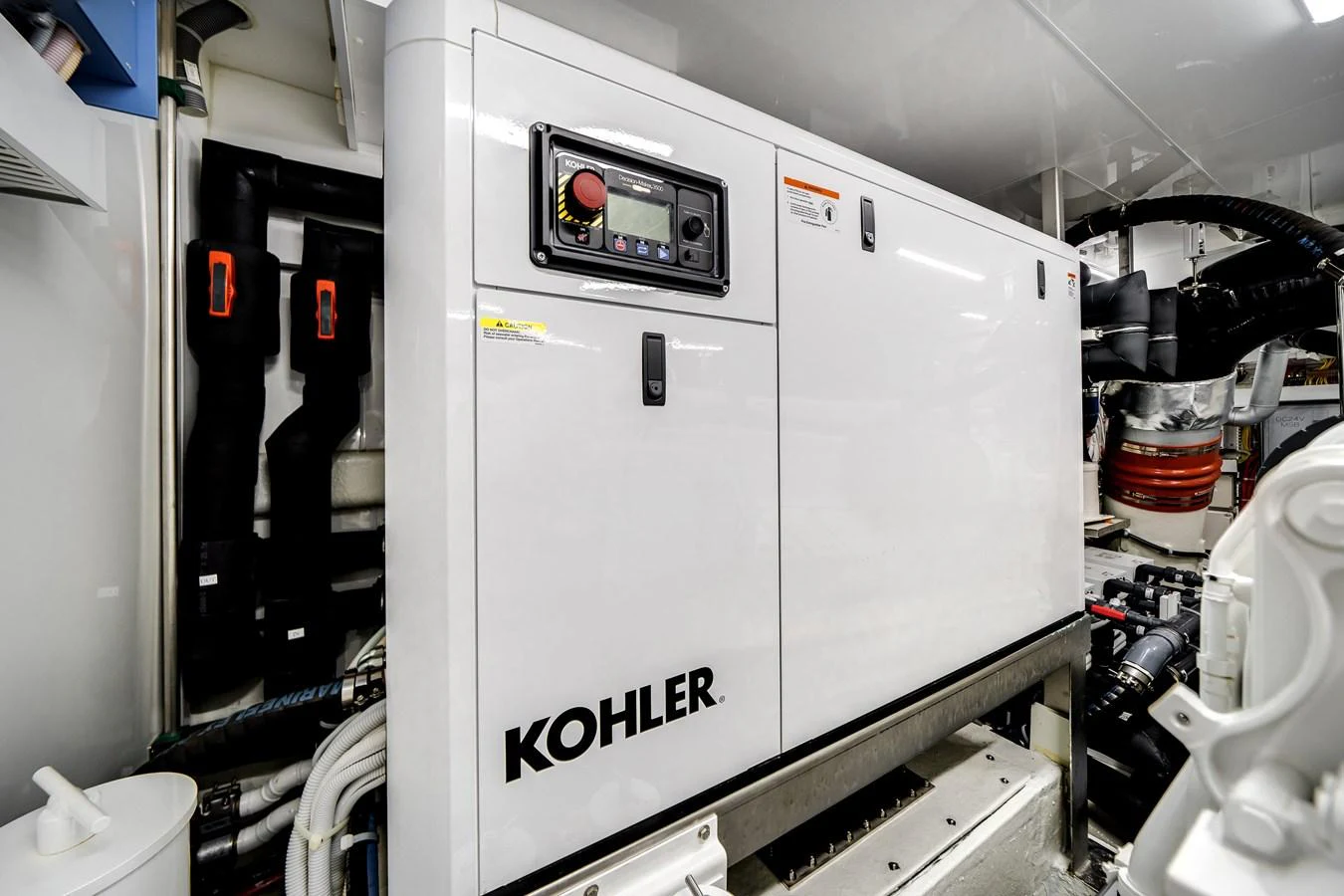 The image showcases a Kohler generator in the yacht's engine room. aboard OCEAN ALEXANDER 37L Yacht for Sale