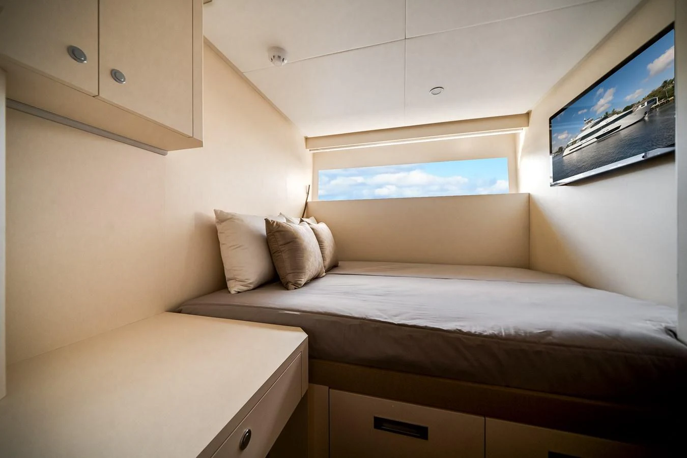 A cozy stateroom with a large bed and a window offering a view of the sea. aboard OCEAN ALEXANDER 37L Yacht for Sale