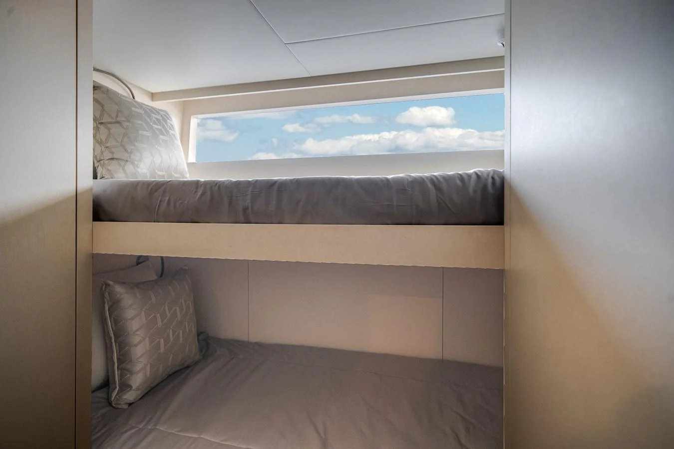 A cozy bunk cabin with a window offering a view of the sky and clouds. aboard OCEAN ALEXANDER 37L Yacht for Sale