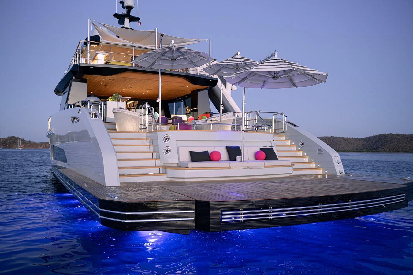 The yacht's aft deck features a luxurious lounging area with umbrellas and ambient lighting, perfect for relaxation. aboard SPRITZ 116 Yacht for Sale