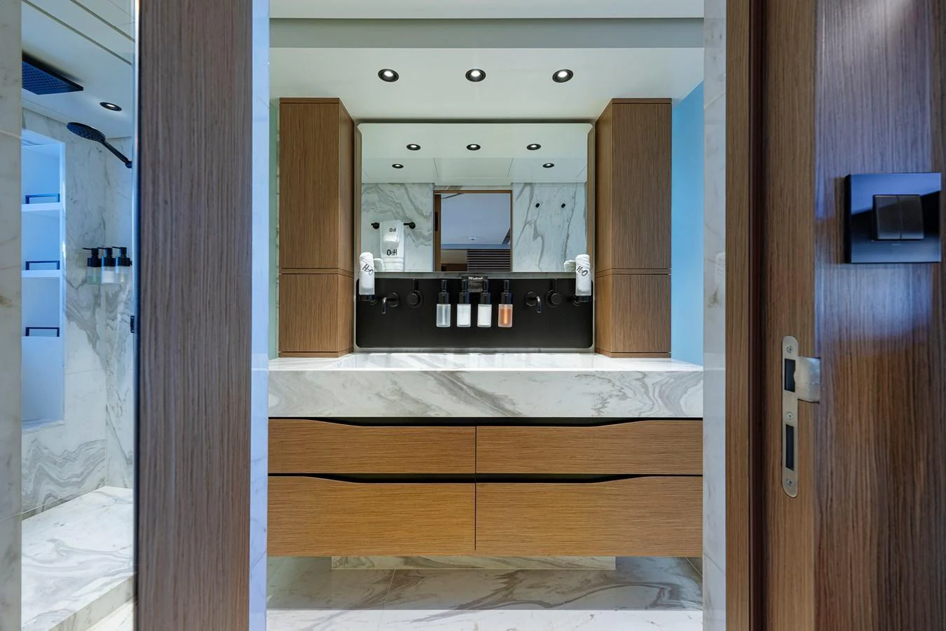 The yacht's bathroom features a modern design with wood accents and a marble countertop. aboard SPRITZ 116 Yacht for Sale
