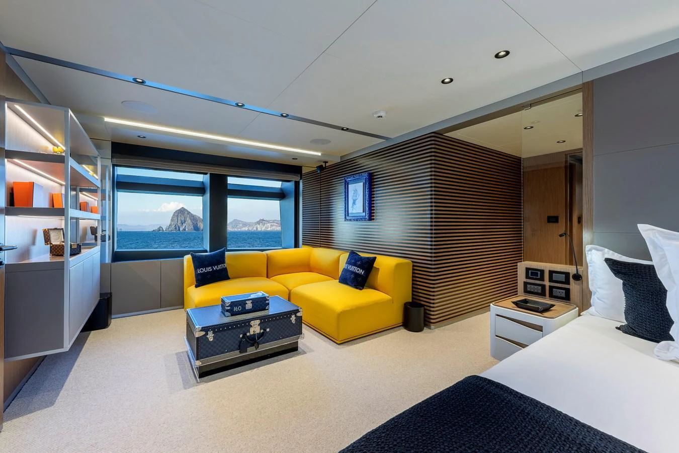 A luxurious stateroom featuring a vibrant yellow sofa and expansive windows with a stunning ocean view. aboard SPRITZ 116 Yacht for Sale