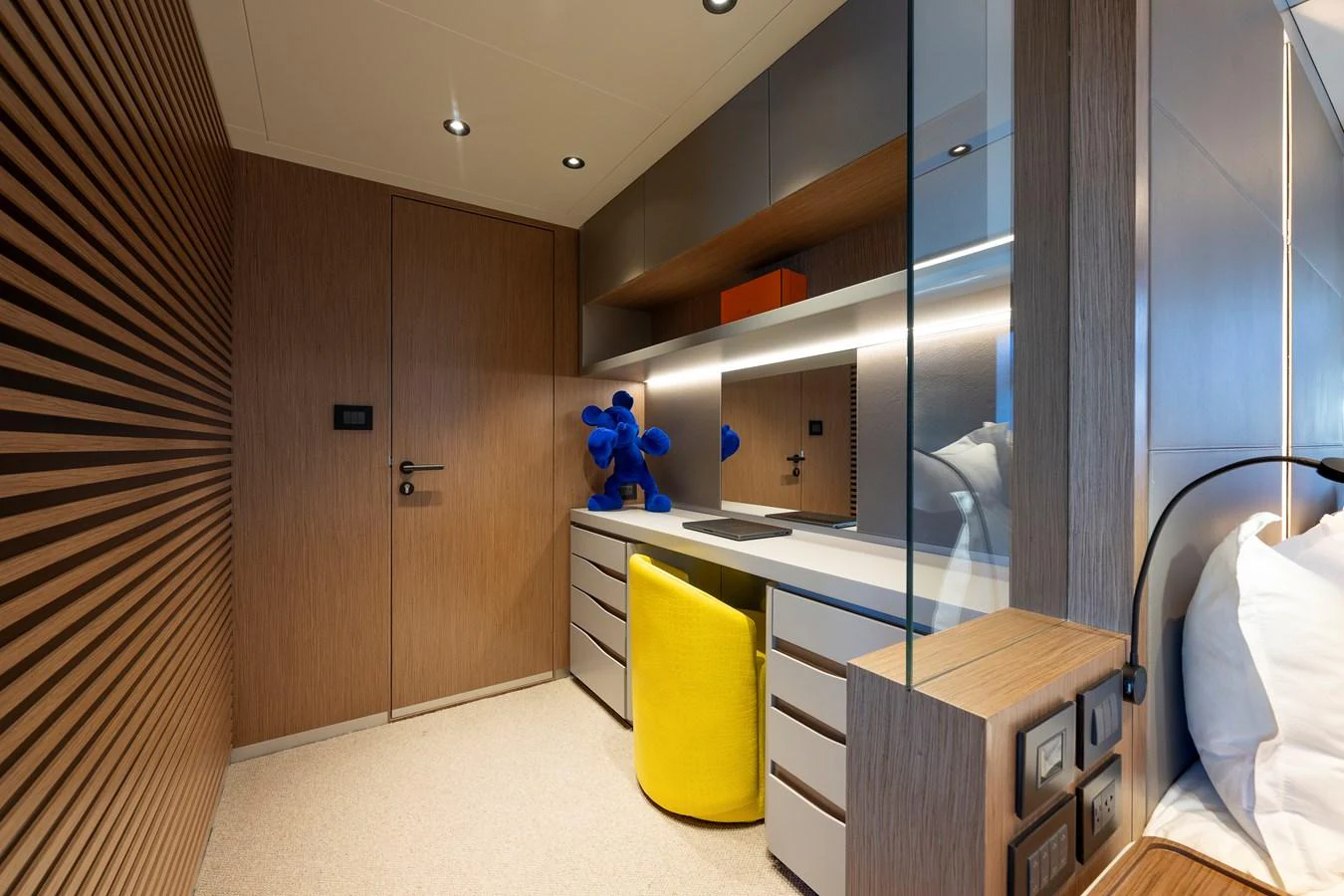 A modern stateroom with a sleek desk area and vibrant yellow chair. aboard SPRITZ 116 Yacht for Sale