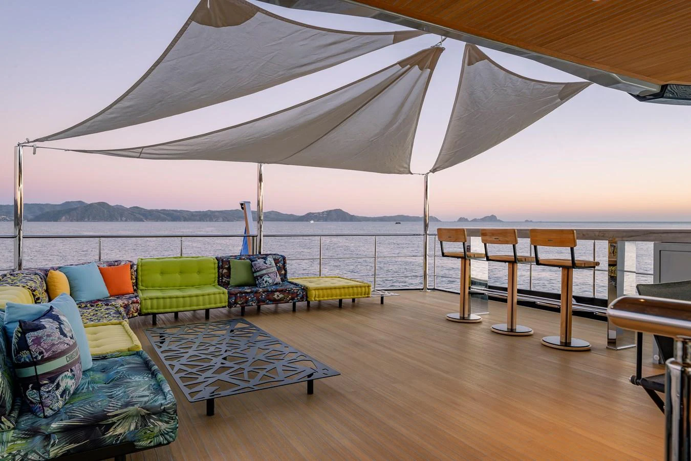 The aft deck features a spacious seating area with colorful cushions and a stylish canopy, perfect for enjoying panoramic views. aboard SPRITZ 116 Yacht for Sale