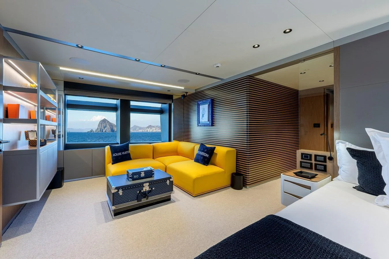 A luxurious stateroom featuring a vibrant yellow sofa and large windows with a stunning ocean view. aboard SPRITZ 116 Yacht for Sale