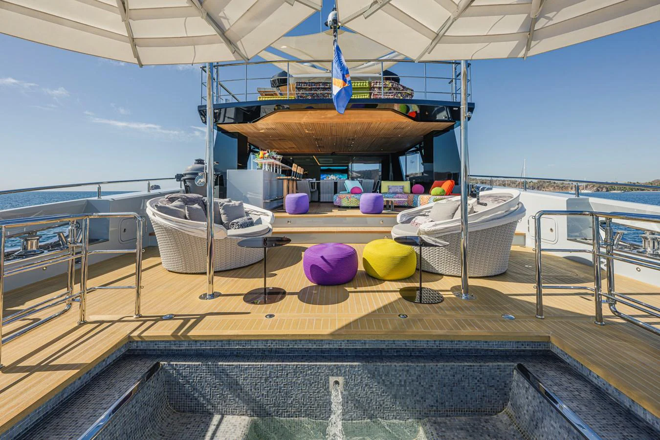 The sundeck features a jacuzzi and ample seating under large umbrellas, perfect for relaxation. aboard SPRITZ 116 Yacht for Sale