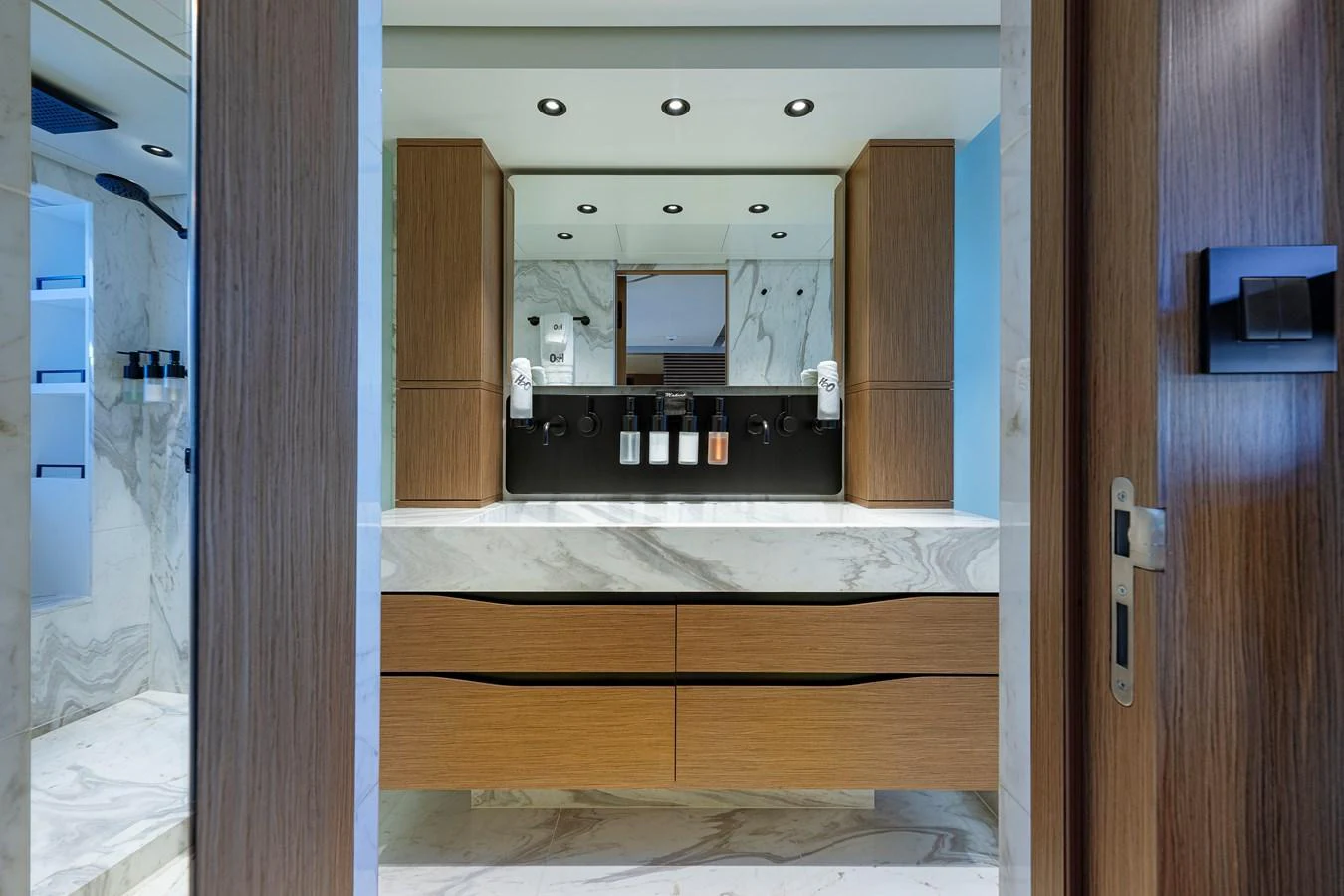 The yacht's bathroom features a modern design with wooden cabinetry and marble surfaces. aboard SPRITZ 116 Yacht for Sale