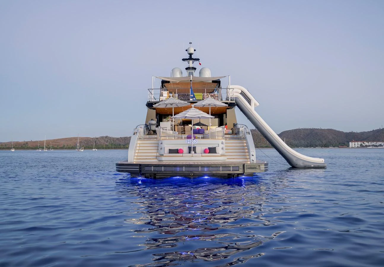The yacht's aft deck features a slide and inviting lounging areas, perfect for water activities and relaxation. aboard H2O - SPRITZ 116 Yacht for Sale