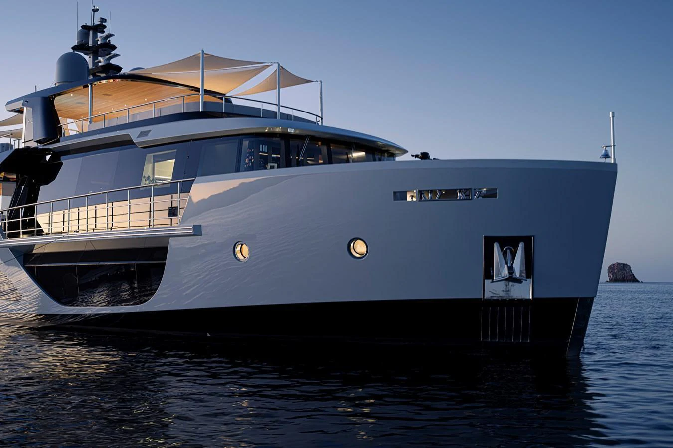 A sleek and modern yacht is anchored on calm waters at dusk. aboard H2O - SPRITZ 116 Yacht for Sale