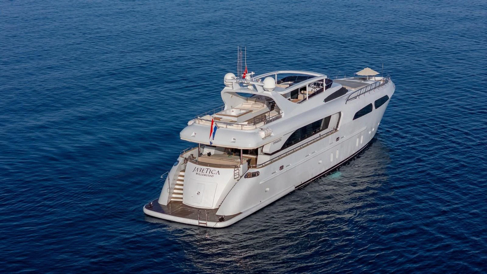 A luxurious yacht glides gracefully on calm blue waters, showcasing its elegant design and spacious decks. aboard JAFE TICA Yacht for Sale