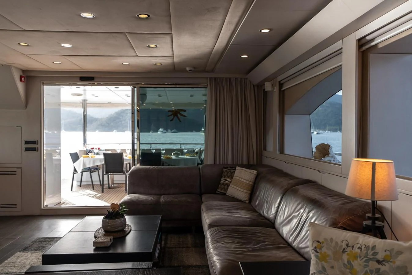 The yacht's salon offers a cozy and inviting space with a view of the outdoor deck and surrounding waters. aboard JAFE TICA Yacht for Sale