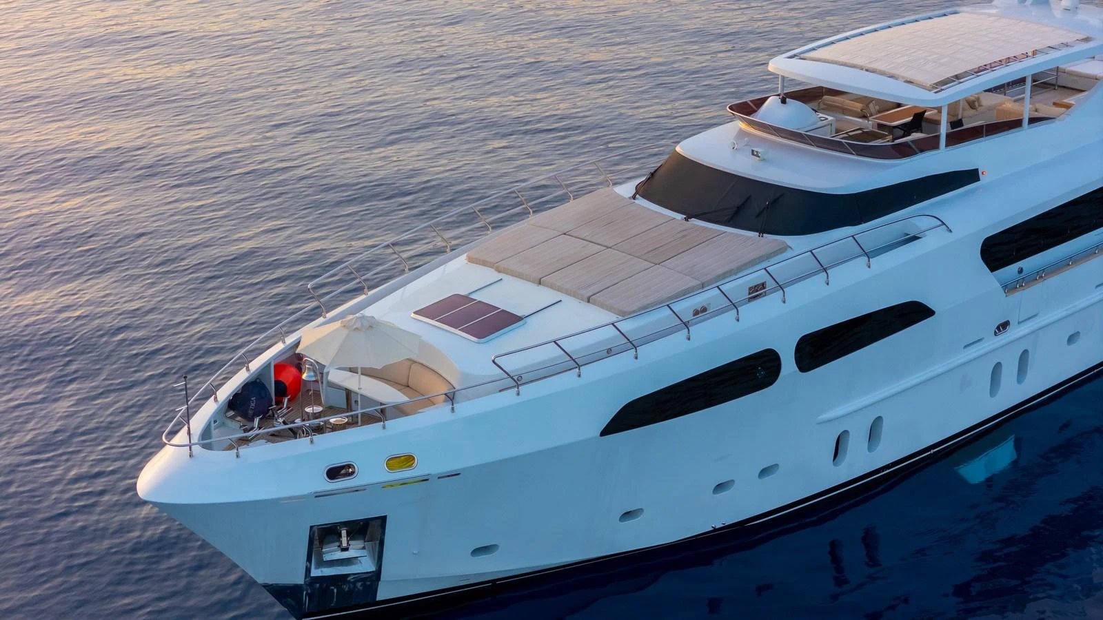 A sleek and modern yacht glides gracefully on calm waters at sunset. aboard JAFE TICA Yacht for Sale