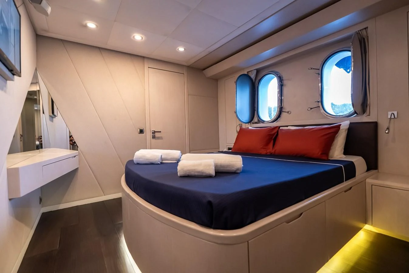 The guest stateroom features a cozy bed with porthole windows providing natural light and a serene ambiance. aboard JAFE TICA Yacht for Sale